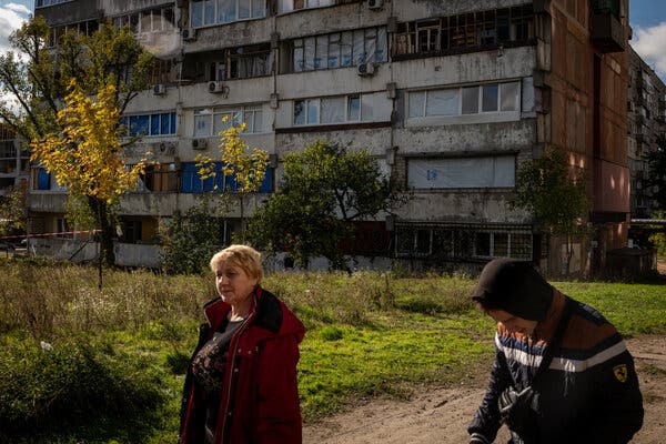 Residents walking past a damaged building in Dnipro, Ukraine, on Tuesday, a day after a Russian missile struck the city.