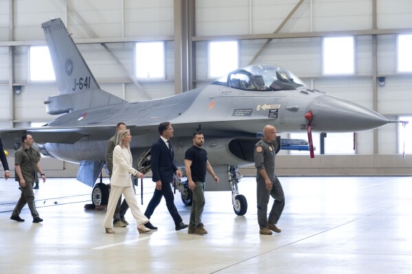 FILE - Ukrainian President Volodymyr Zelenskyy, second right, and Dutch caretaker Prime Minister Mark Rutte, center, look at F-16 fighter jets in Eindhoven, Netherlands, on Aug. 20, 2023. The Dutch government announced Friday Dec. 22, 2023 it is preparing to give 18 F-16 fighter jets to Ukraine, in a boost for the embattled nation that is growing increasingly anxious about aid from its Western allies. (AP Photo/Peter Dejong)