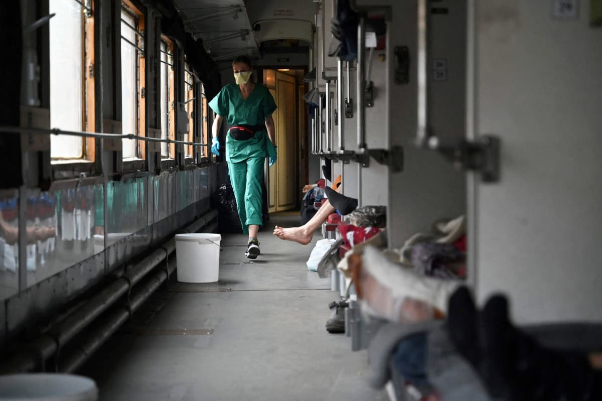 Lääkäri ja potilaita junavaunuun rakennetussa sairaalassa.