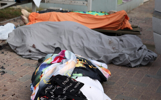 Graphic content: The bodies of Israeli civilians lie covered in the southern city of Sderot on October 7, 2023, amid an unprecedented infiltration into Israel by hundreds of gunmen from the Hamas terrorist organization from Gaza. (Oren ZIV / AFP)