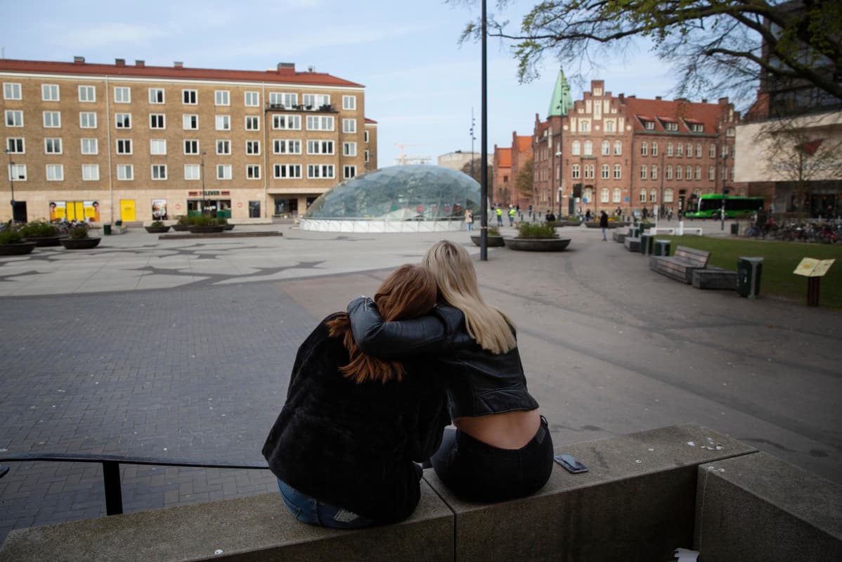 Kaksi malmölaistä nuorta tyttöä halaa toisiaan ulkona.