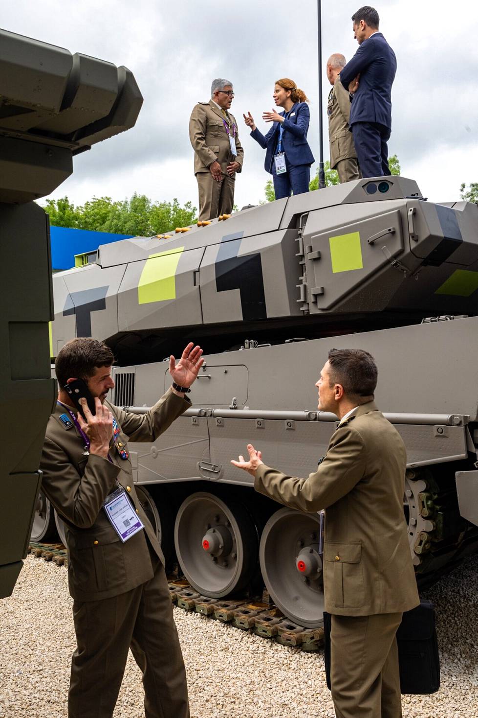 Saksalaisen Rheinmetallin edustaja selosti Leopard-panssarivaunun tornin päällä uuden mallin ominaisuuksia kahdelle italialaiskenraalille.