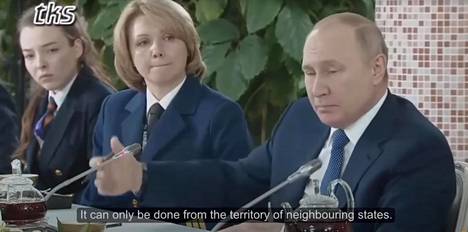 Todisteena vihreän taustan käytöstä on pidetty Venäjän tv-lähetyksessä ollutta kohtaa, jossa Putinin käsi näyttää menevän pöydällä olleen mikrofonin läpi. Kuvakaappaus Youtubesta.