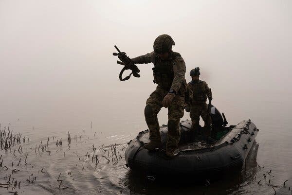 Soldiers getting out of a boat on the Dnipro river.