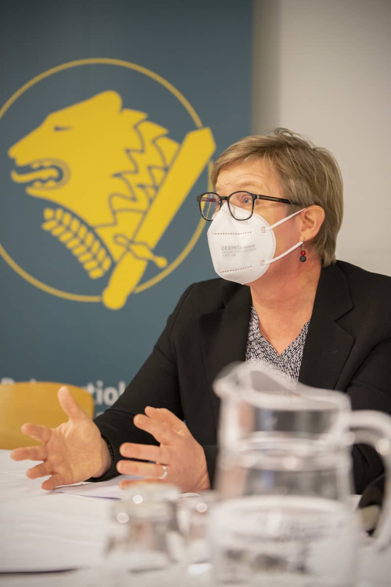 Sisäministeri Krista Mikkonen puhuu tiedotustilaisuudessa Rajavartiolaitoksen logon vieressä.