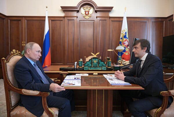 President Vladimir V. Putin of Russia is shown meeting with the country’s eduction minister, Sergei Kravtsov, with both seated at a desk and looking at each other in an ornate office in Moscow in June 2021. 