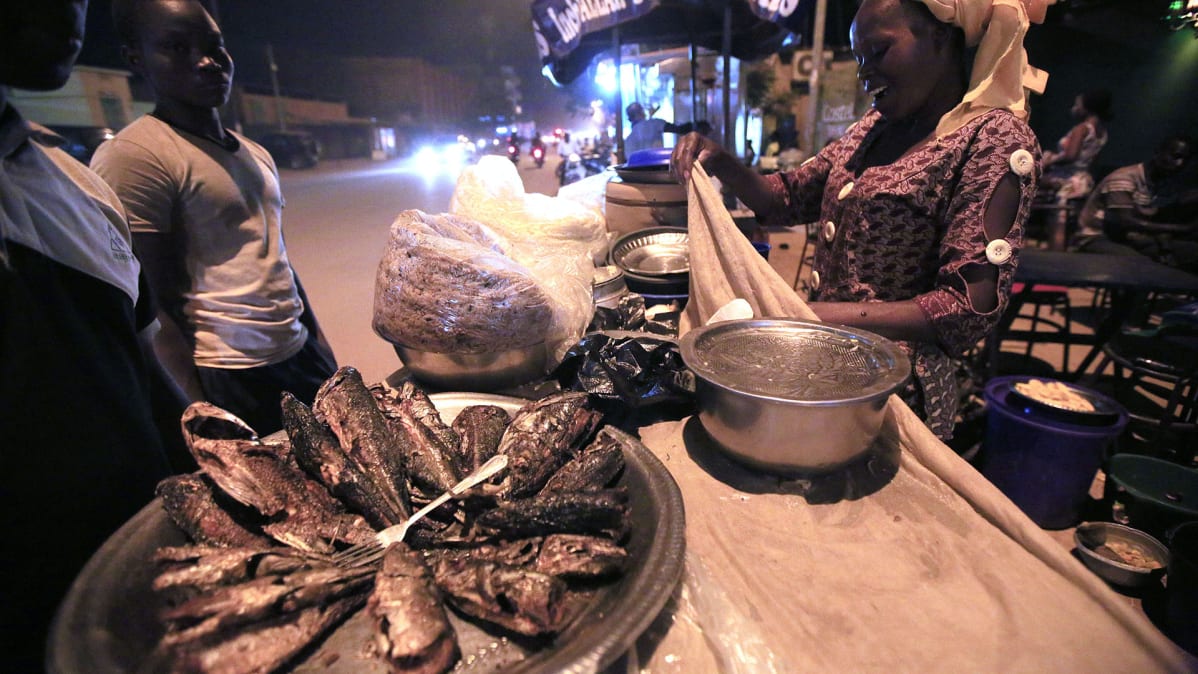 Nainen myy ruokaa kojusta tien varrella  Ouagadougoussa, Burkina Fasossa.