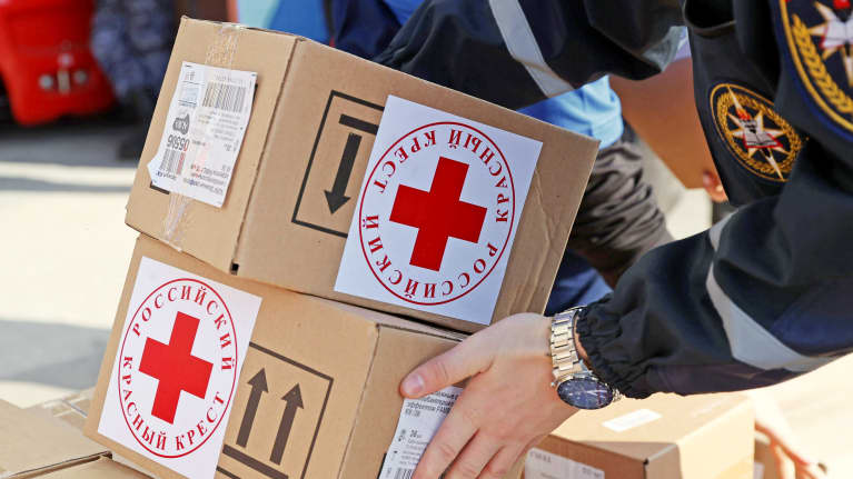 Laatikoissa Punaisen Ristin logo ja tekstiä venäjäksi.