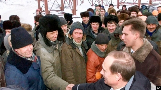 Putin shakes hands with workers during a visit to an oil and gas field in Surgut, Siberia, in March 2000.