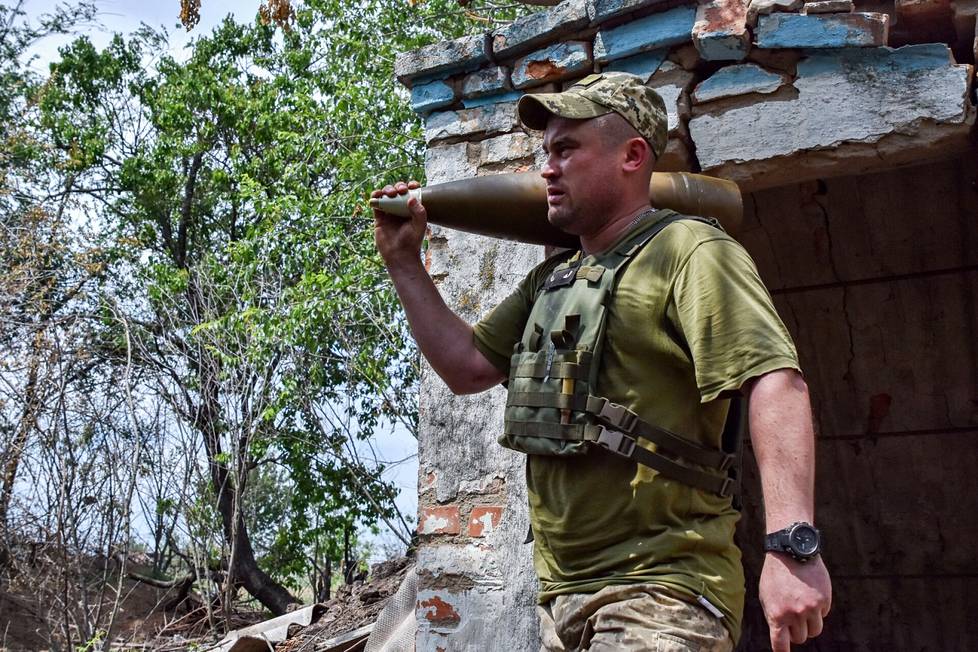 Ukrainalaissotilas kantoi tykistön ammusta Orihivissa Ukrainassa kesäkuun alussa.