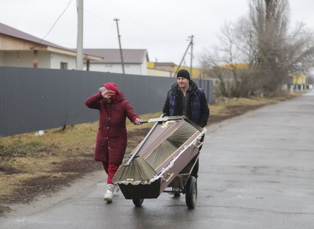 Paikalliset kuljettivat hauta-arkkua Borodjankassa Venäjän iskujen jälkeen.