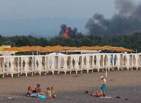 Novofedorivkan lentotukikohdan lähistöllä rantalomaa viettävien ihmisten taustalla näkyi tulenlieskoja ja savua tiistaina.