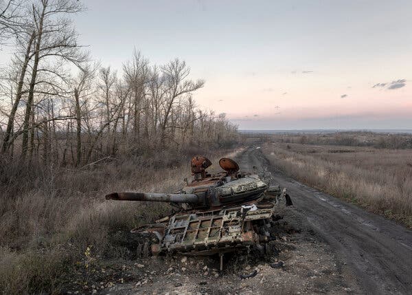 A destroyed armored vehicle near a dirt road.