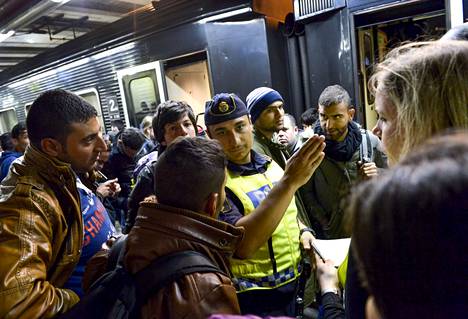 Malmöstä junalla Tukholmaan saapuneet siirtolaiset saivat kulkuohjeita poliisilta syyskuussa 2015.