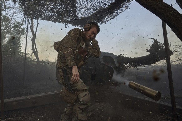 A Ukrainian serviceman of the 10th Assault Brigade Edelweiss fires a D-30 cannon towards Russian positions at the front line, near Bakhmut, Donetsk region, Ukraine, on July 5, 2023. (AP Photo/Libkos)