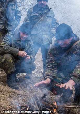 25B4697300000578-2954289-Ukrainian_soldiers_keep_warm_as_they_stand_around_a_fire_along_t-a-64_1424026835191.jpg