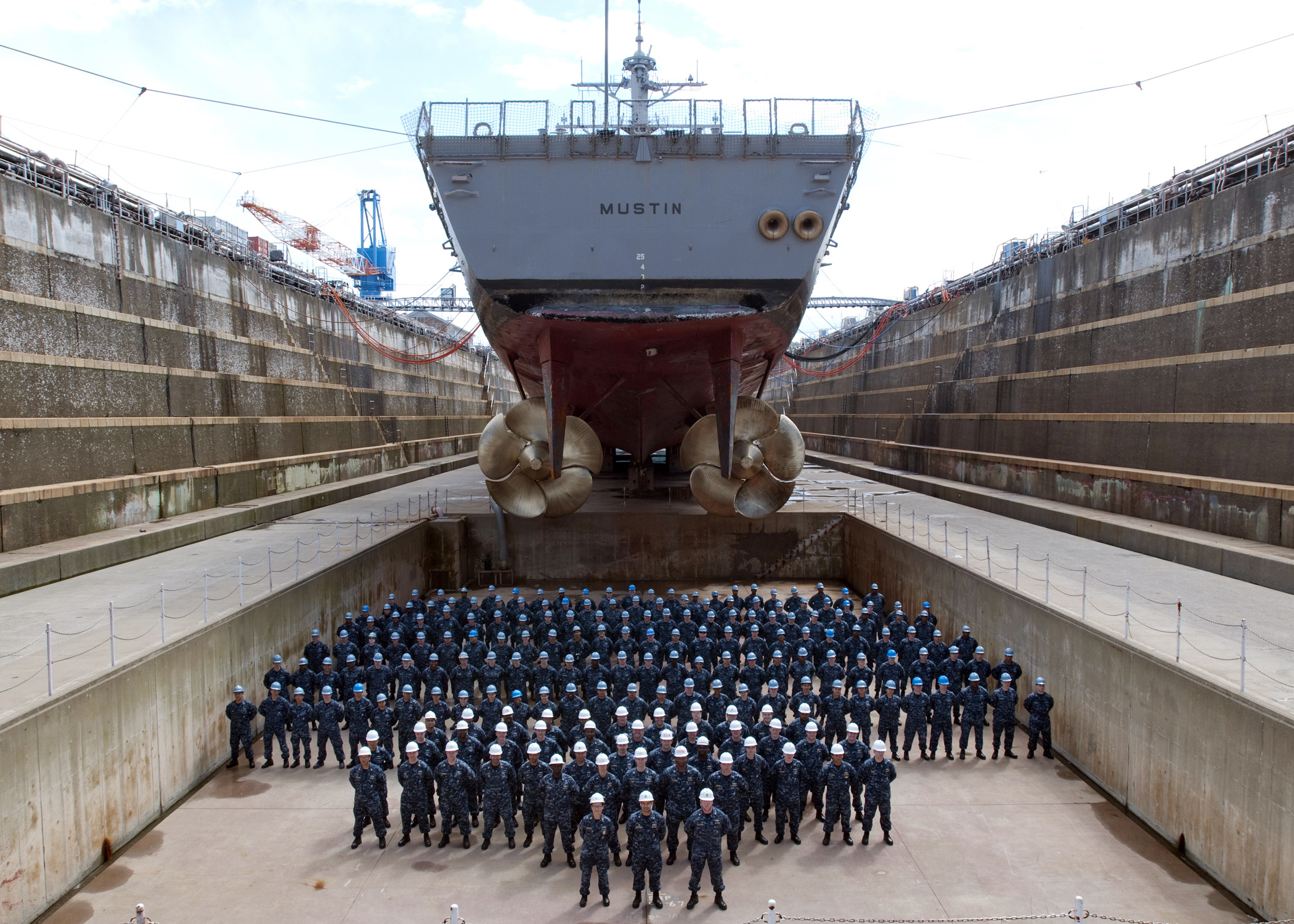 US_Navy_100527-N-2218S-002_The_officers_and_crew_of_the_Arleigh_Burke-class_guided-missile_destroyer_USS_Mustin_%28DDG_89%29_pose_for_a_group_photo_under_the_ship%27s_screws_at_Fleet_Activities_Yokosuka.jpg