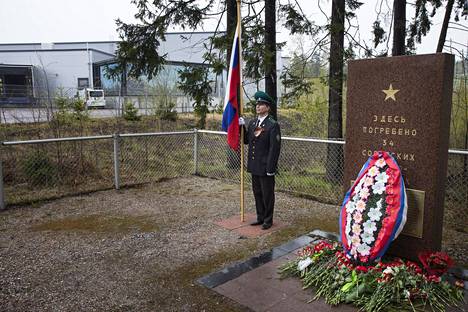 Venäläissotilas seisoi kunniavartiossa Kivikon venäläisvankien haudalla voiton päivänä 9. toukokuuta 2014. Taustalla näkyy teollisuusrakennus.