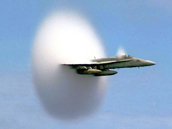 A cloud forms as this F/A-18 Hornet aircraft speeds up to supersonic speed.