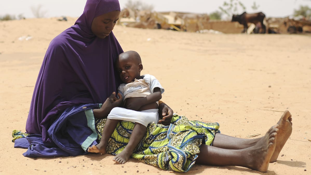 Äiti lapsi sylissään odottaa ruoka-apua  Nigerissä vuonna 2012.