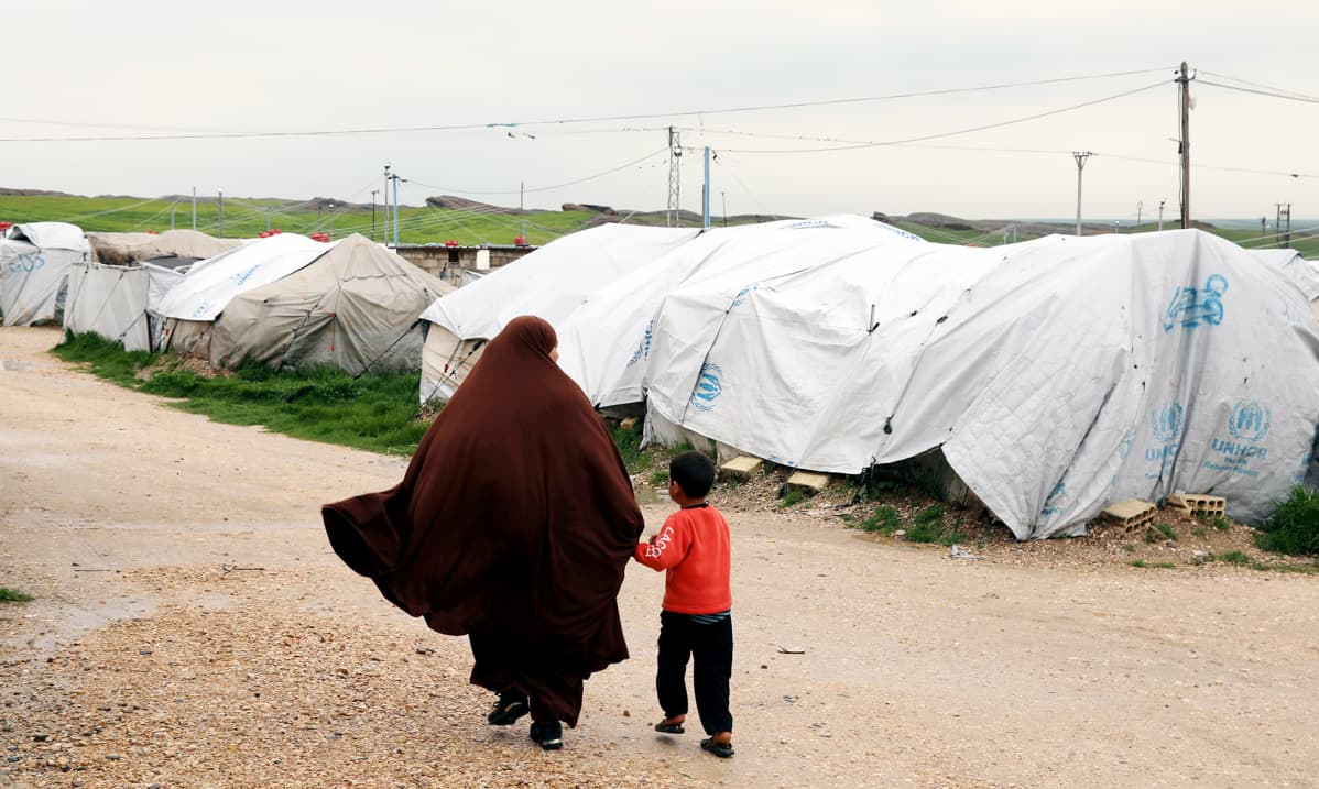 Isis-taistelijaksi epäillyn miehen vaimo käveli maaliskuussa poikansa kanssa Rojin pakolaisleirillä Koillis-Syyriassa.