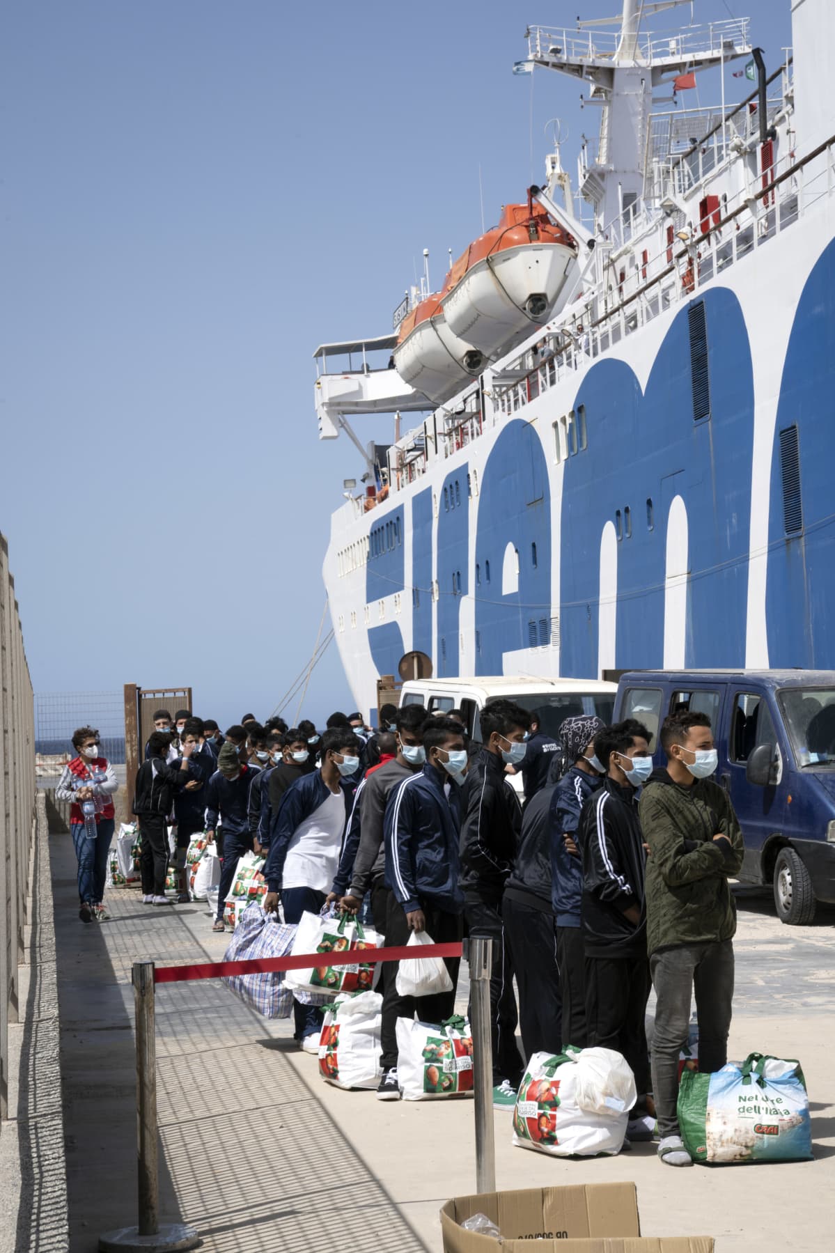 Siirtolaisi jonossa satamassa Lampedusassa.