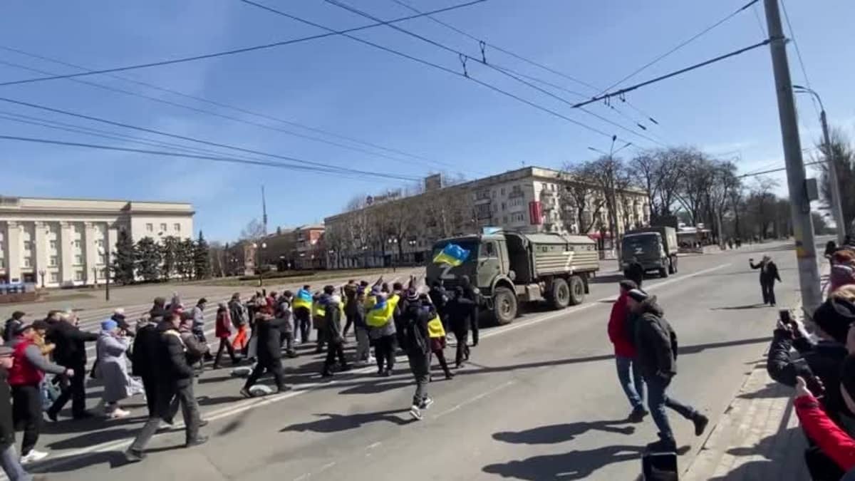 Ukrainalaiset mielenosoittajat huutavat venäläisille joukoille autoissa. Ukrainalaiset mielenosoittajat huutavat venäläisille joukoille autoissa.
