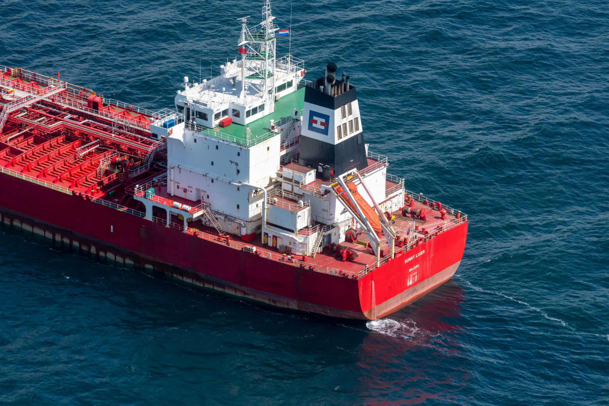 Punarunkoinen öljytankkeri ilmakuvassa. Alus näyttää kulkevan kuvassa vasemmalle yläviistoon aurinkoisena päivänä.