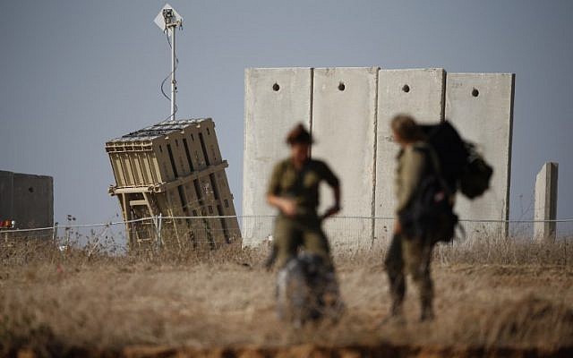 Israeli soldiers walk near an Iron Dome defense system, designed to intercept and destroy incoming short-range rockets and artillery shells on August 9, 2018. (AFP PHOTO / Jack GUEZ)