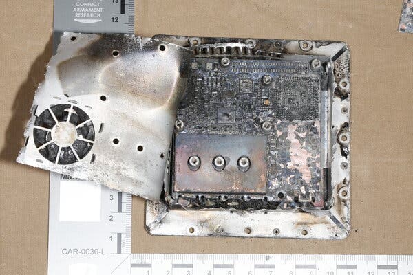 A ruler shows the size of burned electronics that are used for satellite navigation in a Russian attack drone.